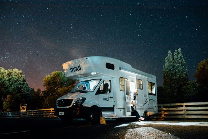A white camper van parked under a starry night sky, illustrating the need for reliable mobile internet for RV travelers.